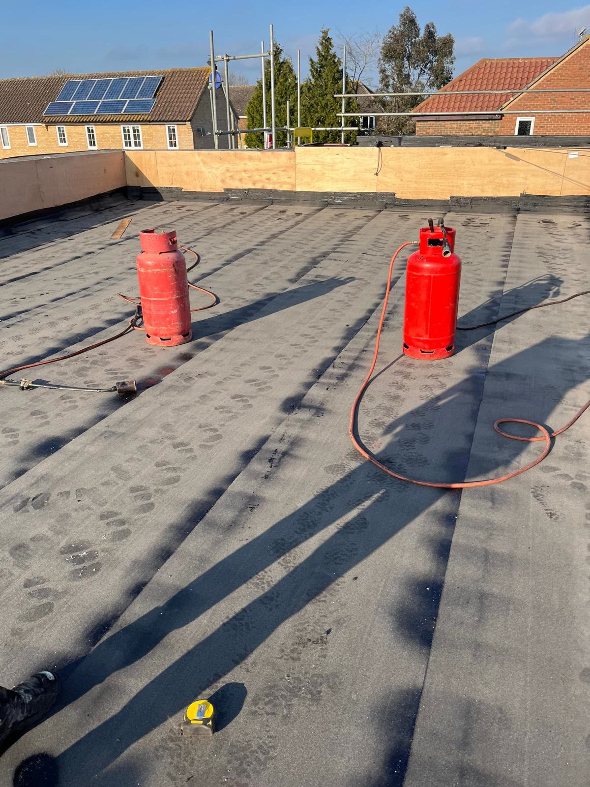 Flat roof with new felt layers being torched on