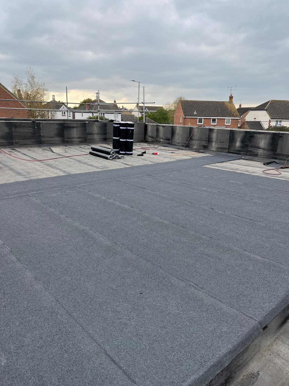 Large flat roof with new felt being laid